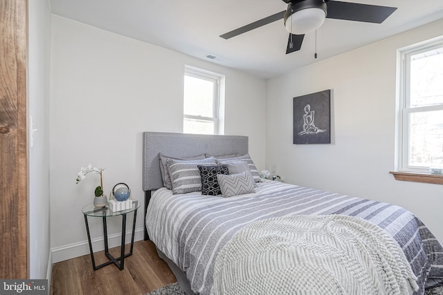 bedroom featuring hardwood / wood-style floors, ceiling fan, and multiple windows