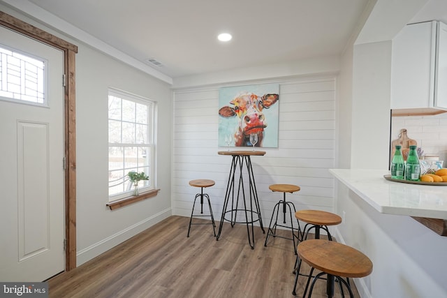 dining area with hardwood / wood-style flooring and wooden walls