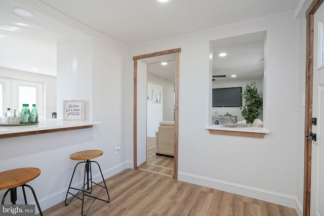 interior space with a breakfast bar area and light hardwood / wood-style flooring