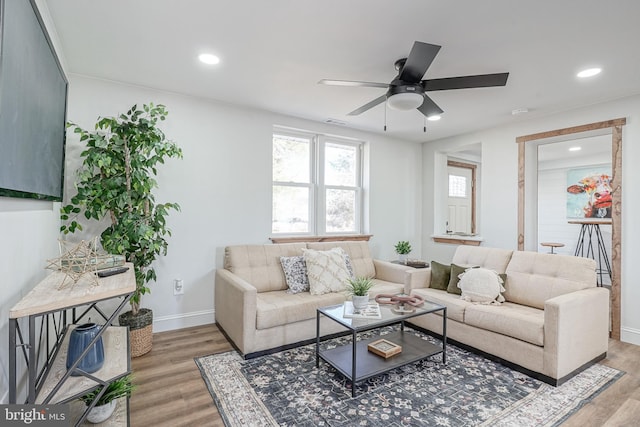 living room featuring wood-type flooring and ceiling fan