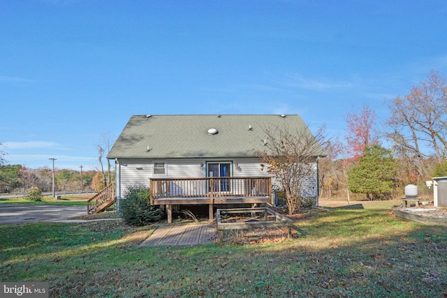 rear view of house featuring a yard and a wooden deck