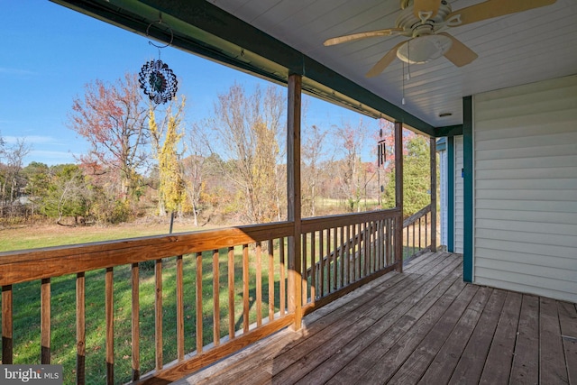 wooden deck with ceiling fan and a lawn