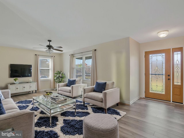 living room with light wood-type flooring and ceiling fan