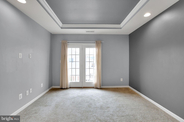 carpeted empty room with a tray ceiling and crown molding