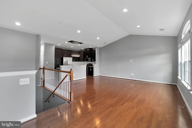 unfurnished living room featuring dark hardwood / wood-style floors and vaulted ceiling