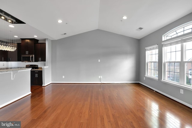 kitchen featuring a breakfast bar, dark hardwood / wood-style flooring, dark brown cabinetry, and vaulted ceiling