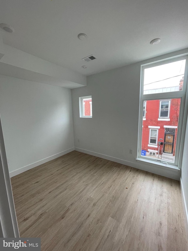 empty room with a healthy amount of sunlight and light hardwood / wood-style flooring