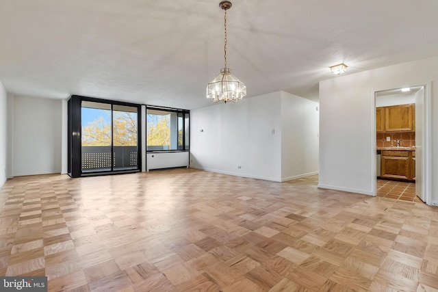 unfurnished room featuring light parquet floors, an inviting chandelier, and sink