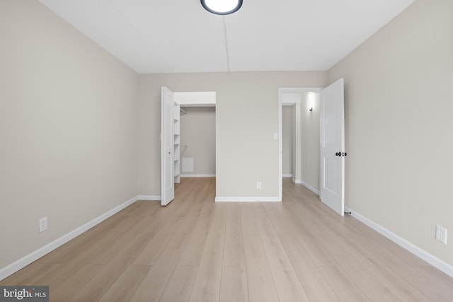 unfurnished bedroom featuring light hardwood / wood-style flooring and a closet