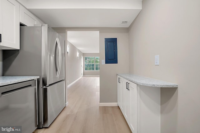 kitchen with electric panel, white cabinetry, dishwasher, and light hardwood / wood-style flooring