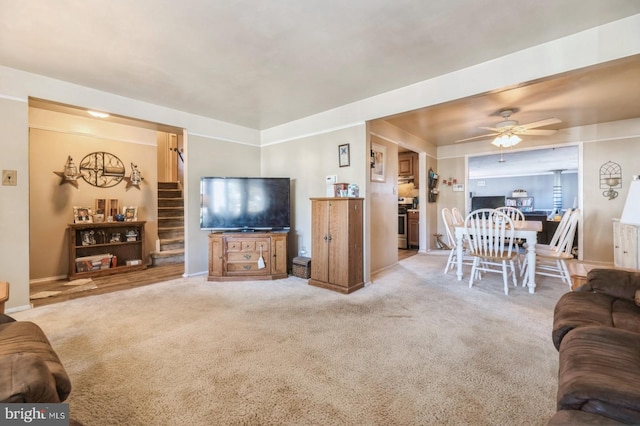 carpeted living room with ceiling fan