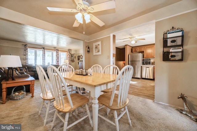 dining room with ceiling fan and light hardwood / wood-style floors