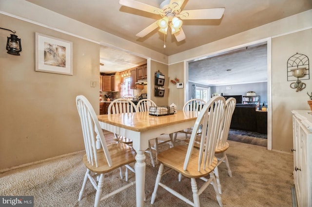 carpeted dining room with ceiling fan