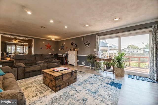 living room featuring crown molding, hardwood / wood-style floors, and ceiling fan