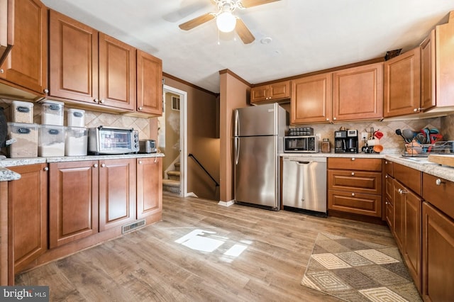 kitchen with backsplash, ceiling fan, ornamental molding, light hardwood / wood-style floors, and stainless steel appliances