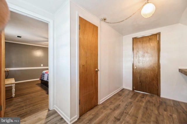 corridor featuring dark hardwood / wood-style flooring and ornamental molding