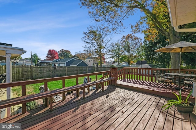 wooden deck featuring a lawn