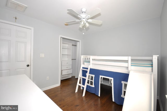 bedroom with ceiling fan, dark wood-type flooring, and a closet