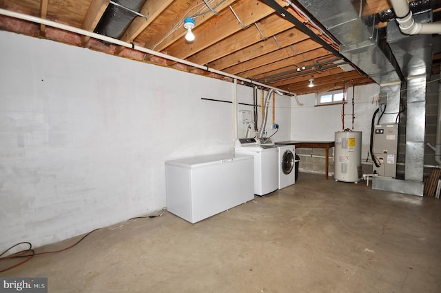 basement featuring washing machine and dryer, refrigerator, and water heater