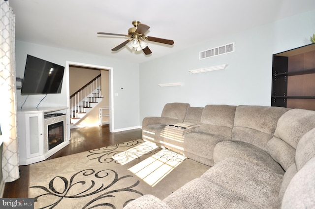 living room with ceiling fan and dark wood-type flooring