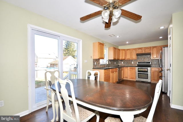 dining room featuring ceiling fan, sink, and dark hardwood / wood-style floors