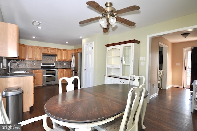 dining area featuring dark hardwood / wood-style floors, ceiling fan, and sink