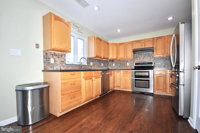 kitchen featuring backsplash, light brown cabinetry, dark wood-type flooring, and stainless steel appliances