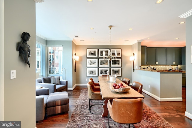 dining space featuring a notable chandelier, dark wood-type flooring, and ornamental molding