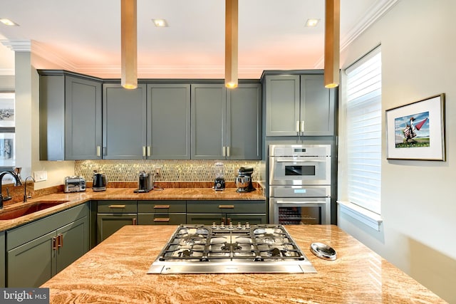 kitchen with ornamental molding, appliances with stainless steel finishes, sink, and decorative backsplash