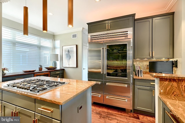 kitchen featuring ornamental molding, appliances with stainless steel finishes, dark hardwood / wood-style floors, and light stone countertops