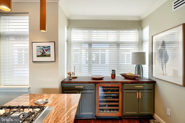 bar with butcher block countertops, ornamental molding, beverage cooler, and stainless steel gas stovetop