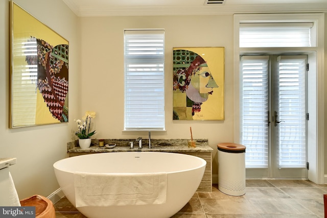 bathroom featuring french doors, ornamental molding, and a washtub