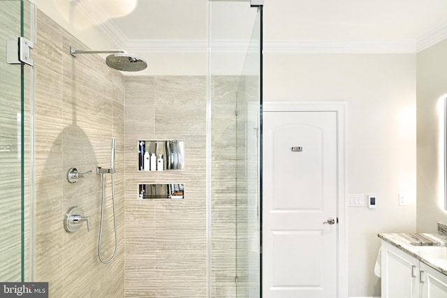 bathroom featuring ornamental molding, vanity, and a tile shower