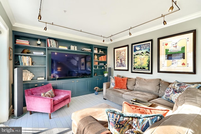 living room featuring track lighting, ornamental molding, light hardwood / wood-style floors, and built in features