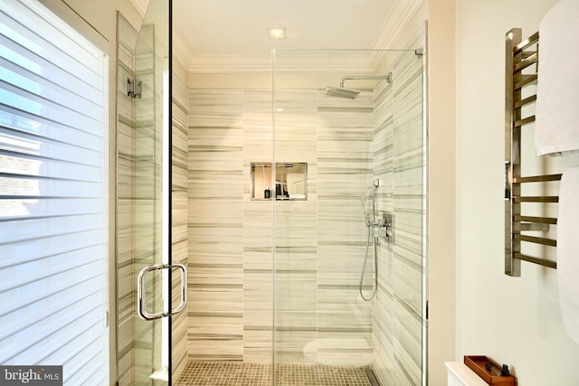 bathroom with ornamental molding and a shower with door