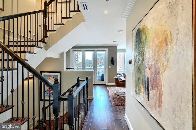 staircase featuring wood-type flooring and ornamental molding