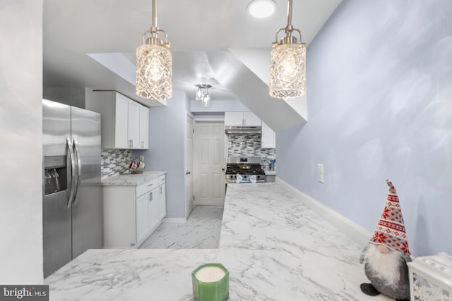 kitchen featuring under cabinet range hood, white cabinets, marble finish floor, appliances with stainless steel finishes, and decorative backsplash