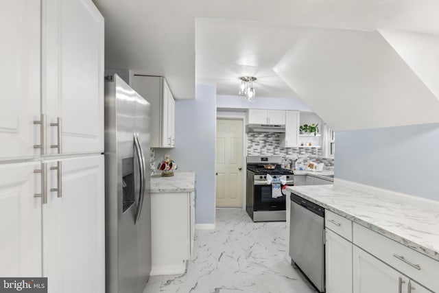 kitchen featuring marble finish floor, stainless steel appliances, backsplash, white cabinetry, and under cabinet range hood