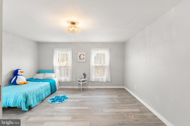 bedroom with baseboards and wood finished floors