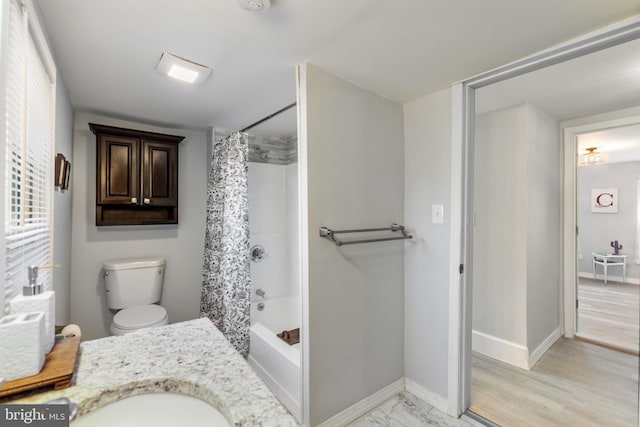 full bathroom featuring toilet, a sink, baseboards, marble finish floor, and shower / bath combination with curtain