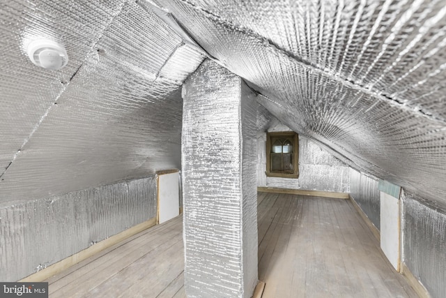 bonus room with lofted ceiling and hardwood / wood-style floors