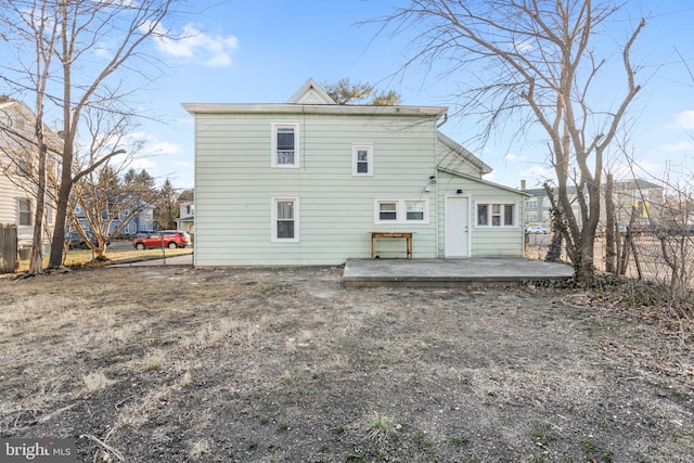 rear view of property featuring a patio area and fence