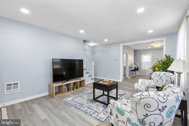 living area with stairs, visible vents, wood finished floors, and recessed lighting