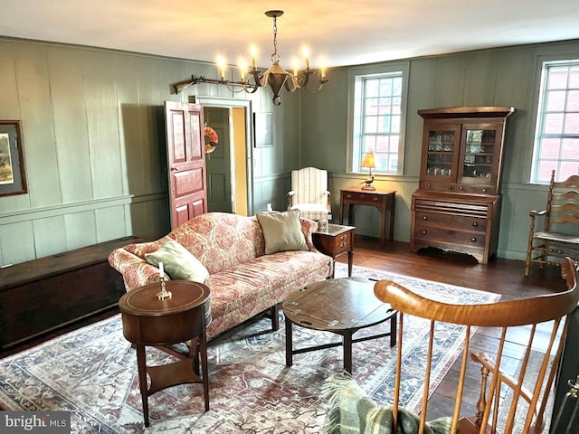 living area featuring wood-type flooring and an inviting chandelier