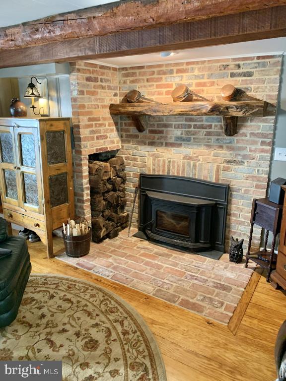 interior details featuring a wood stove and hardwood / wood-style floors