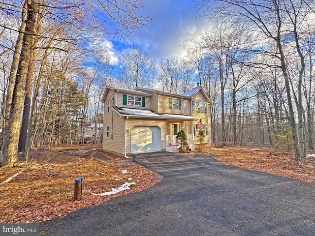 view of front property with a porch and a garage