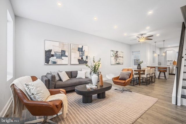 living room with ceiling fan and light hardwood / wood-style floors