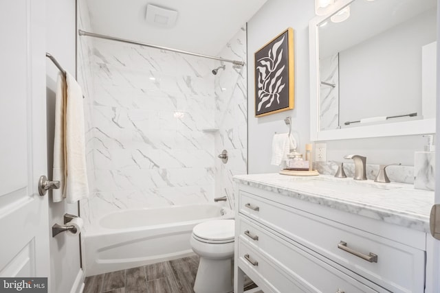 full bathroom with tiled shower / bath, vanity, and toilet