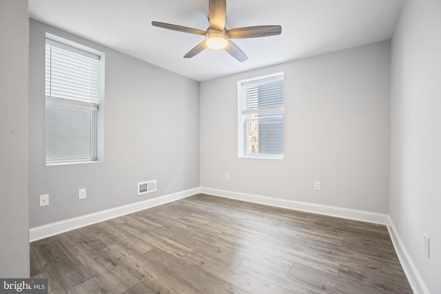 empty room featuring dark wood-type flooring and ceiling fan