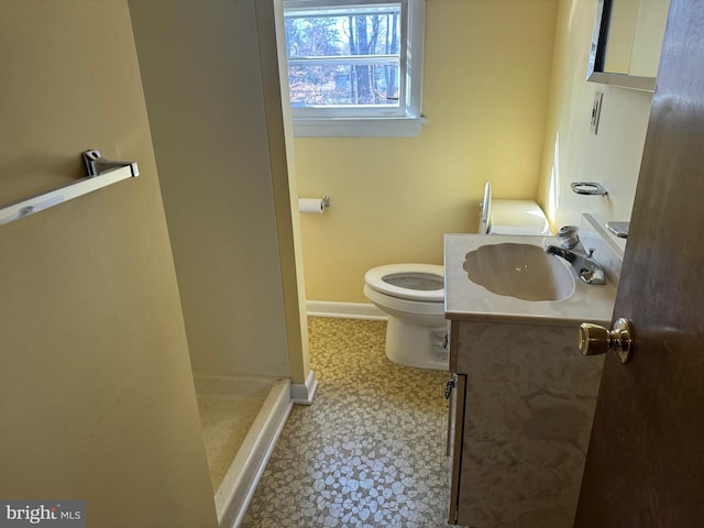 bathroom with tile patterned flooring, vanity, toilet, and walk in shower